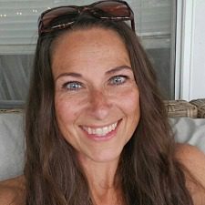 Suzie-female with brown hair smiling wearing sunglasses on her head